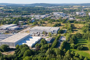 Luftansicht des Logistikparks in Bayreuth. Hallen von Speditionen und LKWs, im Hintergrund das Gewerbegebiet St. Georgen Ost mit Gebäuden von medi, Tennet u.a. sowie die Stadtteile östlich der Autobahn