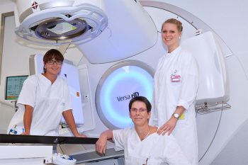 3 Frauen in weißen Kitteln vor modernen medizinischen Geräten
