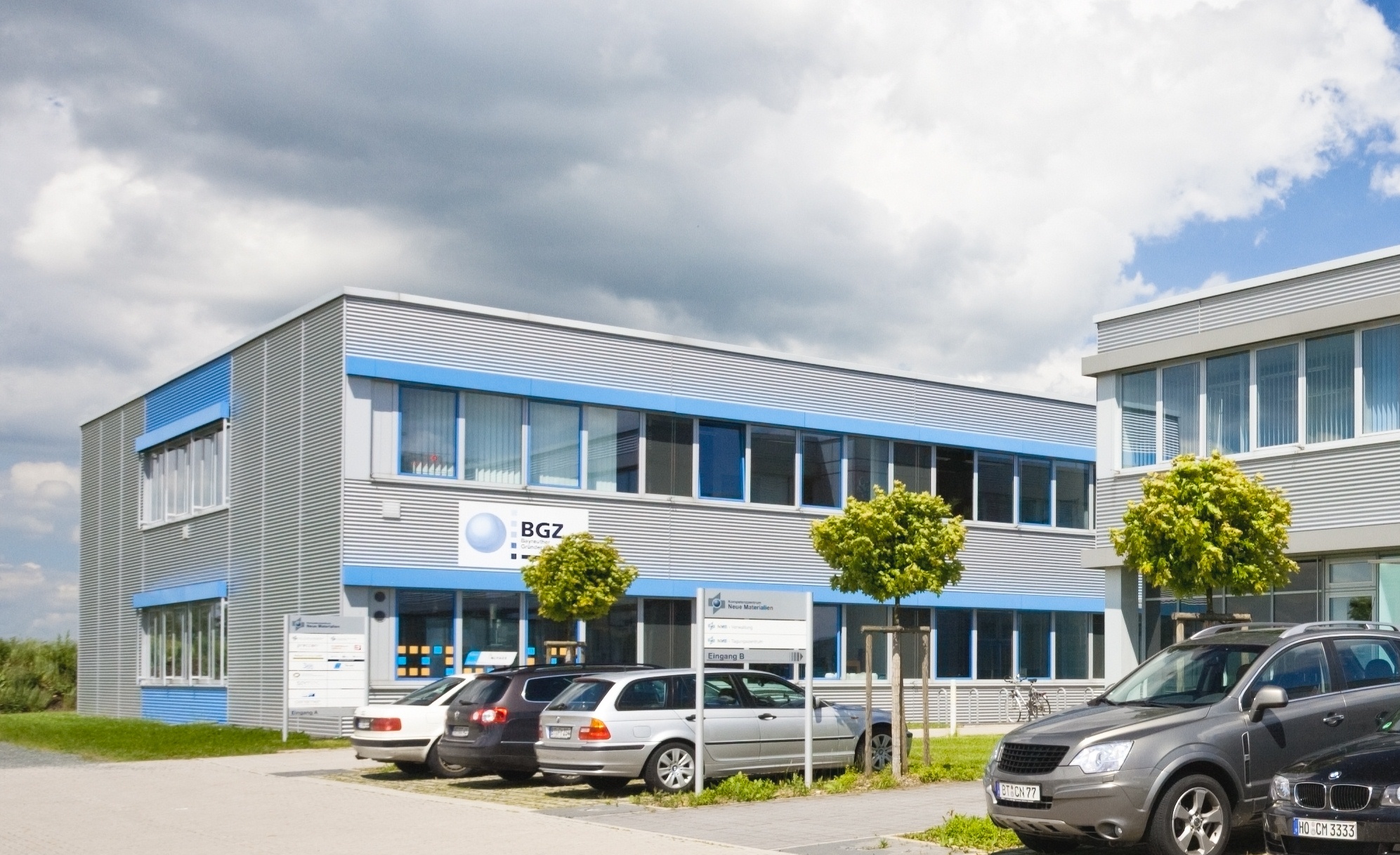 einstöckiges Hallen-/Bürogebäude mit parkenden Autos davor