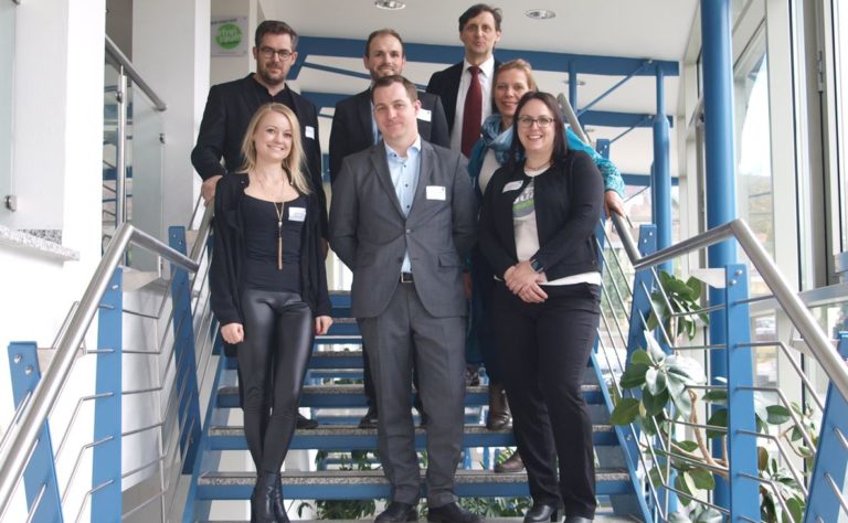 Das Team der Leerstandsmanager - 7 Personen stehen gestaffelt auf einer Treppe