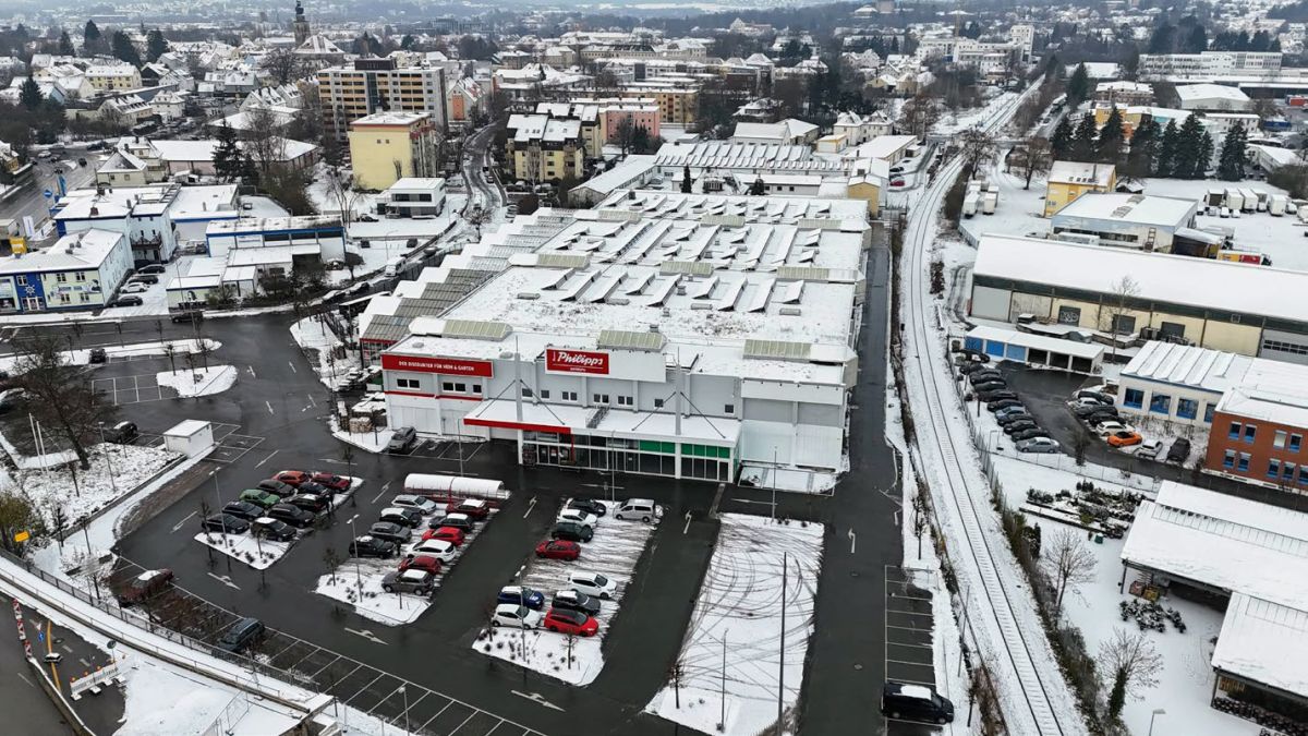 Luftbild von einer schneebedeckten Gewerbehalle mit Parklplatz